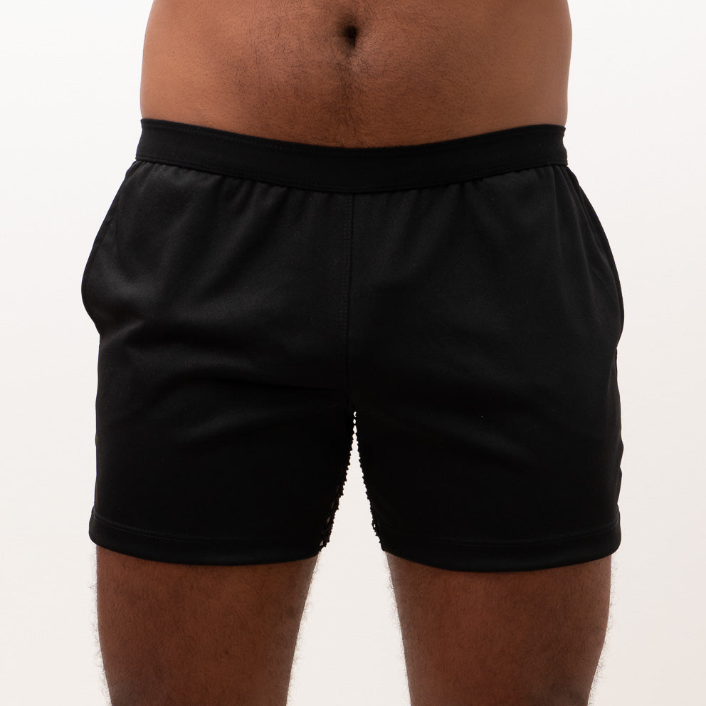 Black mesh back short athletic shorts with smooth stretchy fabric and elastic waistband shown from the back side