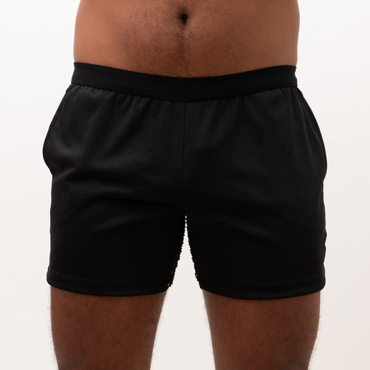 Black mesh back short athletic shorts with smooth stretchy fabric and elastic waistband shown from the back side