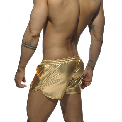 Shiny gold metallic shorts with a sleek form-fitting design and elastic waistband in metallic short style