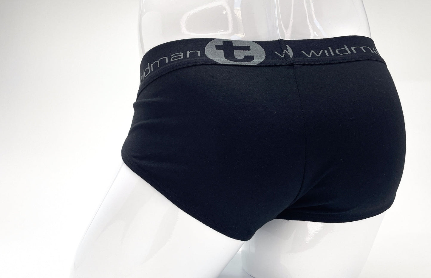 Back view of black stretch cotton pouch briefs on a mannequin, featuring a grey waistband with "wildman" branding.