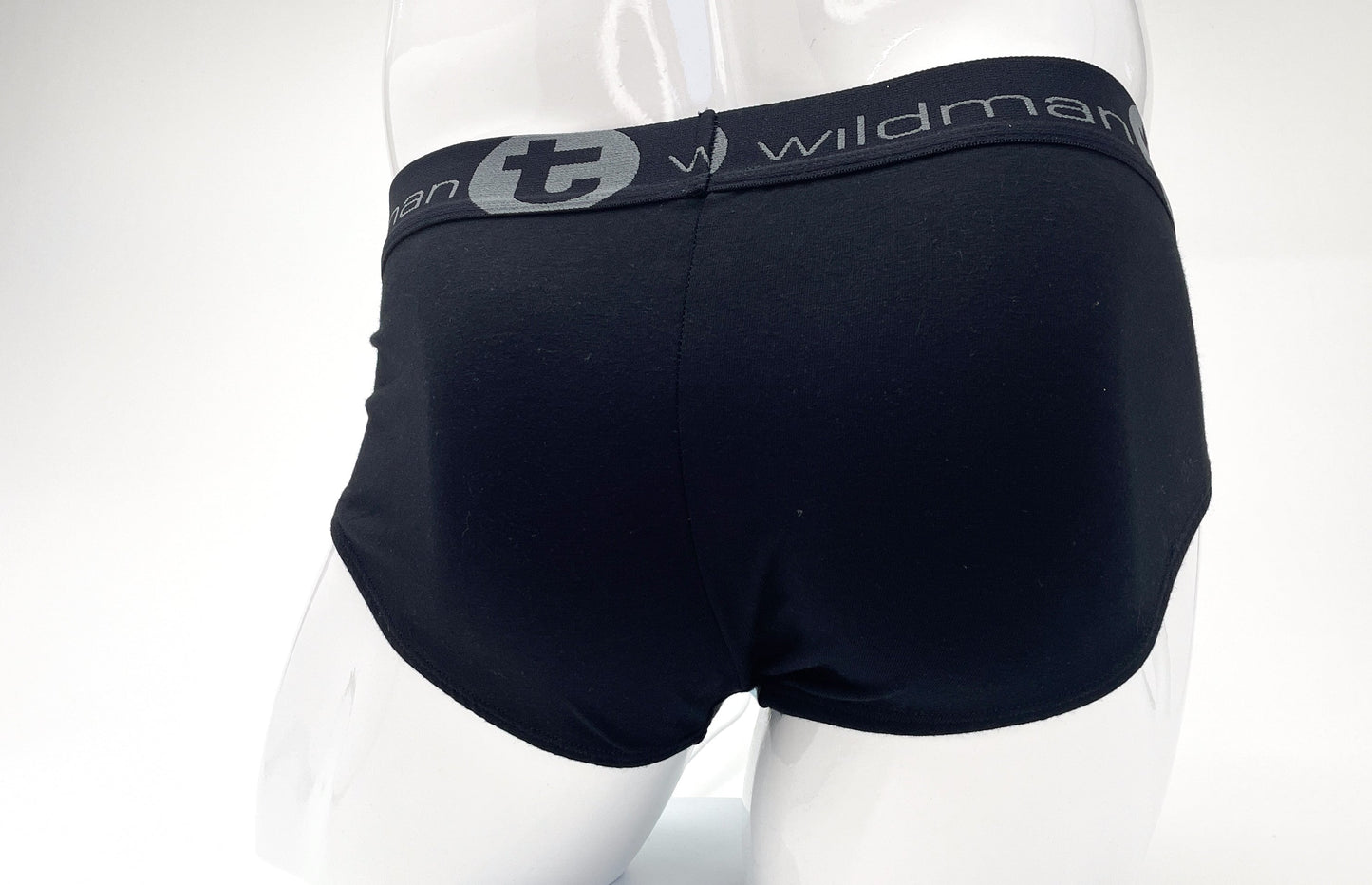 Black stretch cotton briefs on a mannequin, featuring a grey waistband with "Wildman" logo text and a circular "t" icon.