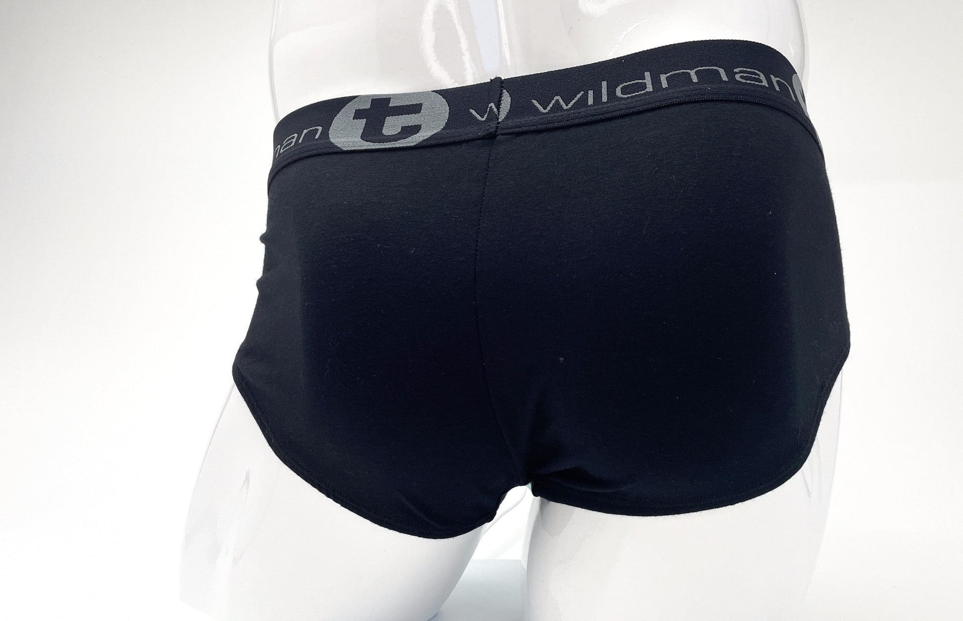 Black stretch cotton briefs on a mannequin, featuring a grey waistband with "Wildman" logo text and a circular "t" icon.