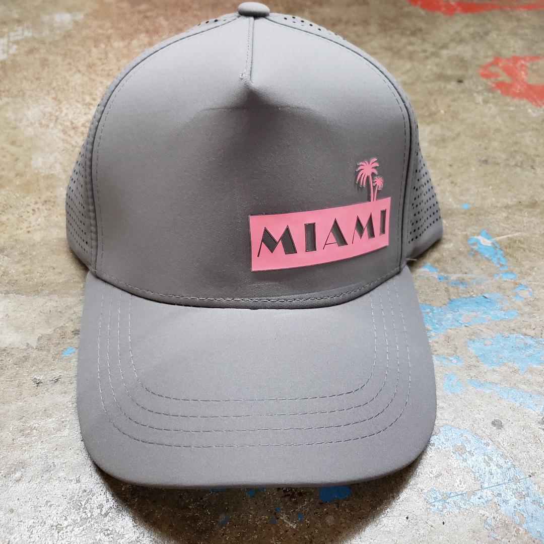 Gray miami baseball cap with pink rectangular patch featuring black lettering and palm trees on front