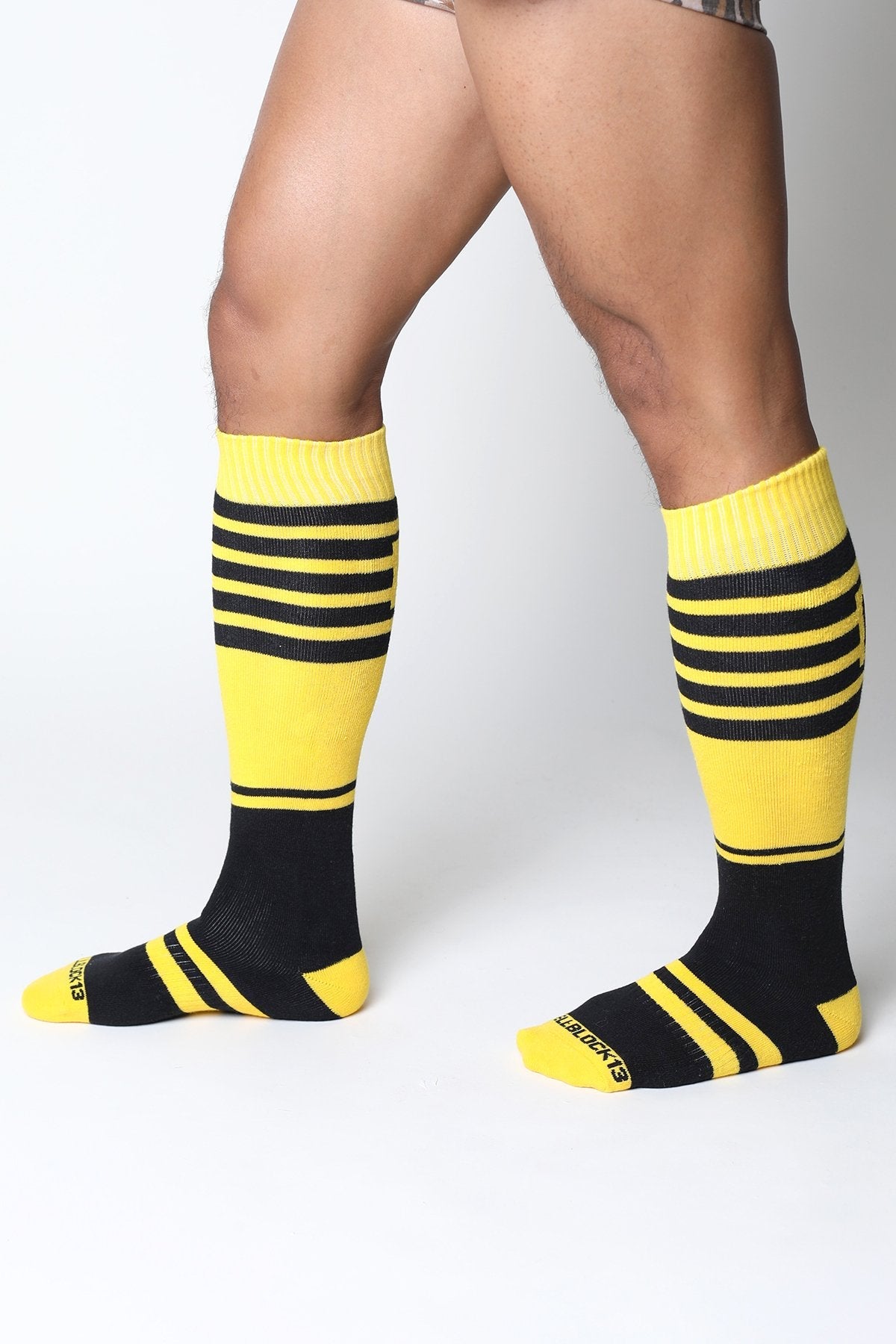 Bright yellow and black striped midfield knee high socks with ribbed cuff and extraboots branding on the heel