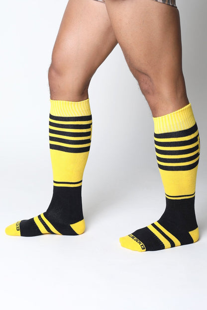 Bright yellow and black striped midfield knee high socks with ribbed cuff and extraboots branding on the heel