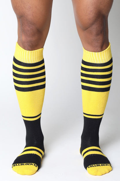 Midfield knee high sock in bright yellow and black stripes with ribbed texture and cellblock13 logo on the toe