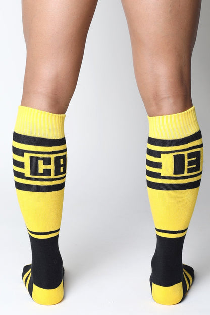 Midfield knee high socks in bright yellow and black with bold stripes and a prominent cb logo in the center
