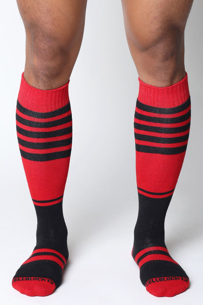 Midfield knee high socks in red and black stripes with ribbed texture and cellblock 13 branding on the toe