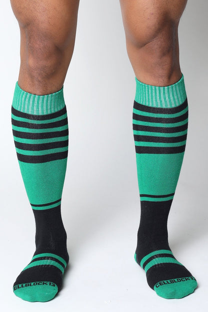 Midfield knee high socks in vibrant teal and black stripes with ribbed cuffs and cellblock branding on the toe