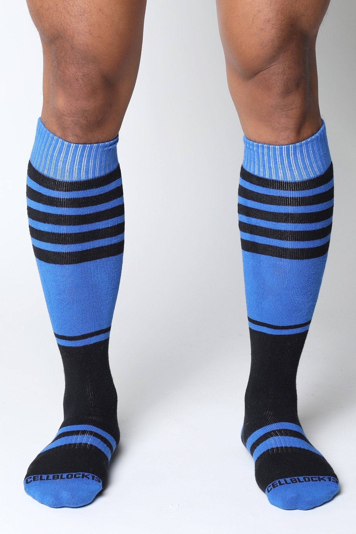Midfield knee high socks in blue and black stripes with ribbed cuffs featuring the cellblock brand name on the toe