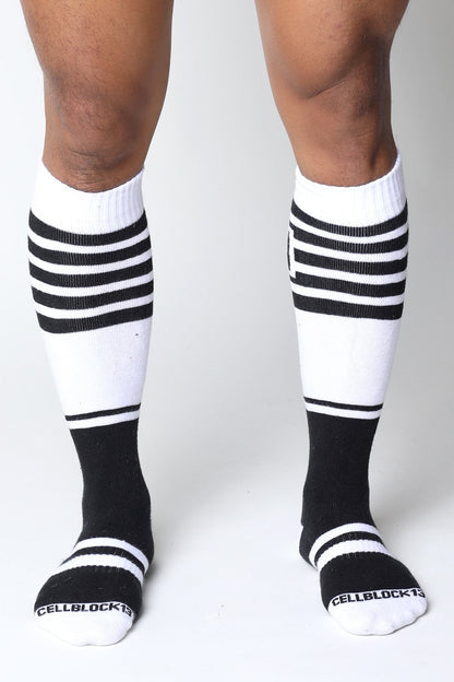 Black and white striped midfield knee high socks with ribbed texture and cellblock brand name on toe