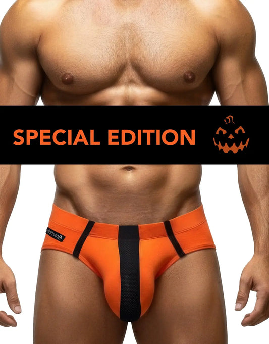 A cropped male model wearing bright orange briefs with a black center panel and black side straps. A black horizontal banner across the chest reads 'SPECIAL EDITION' with an orange jack-o'-lantern graphic.