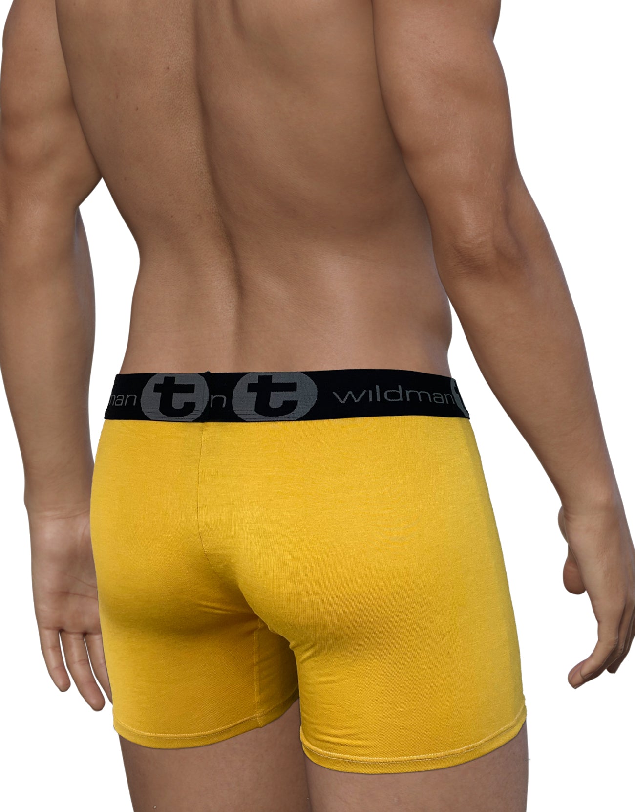 Back view of a man wearing gold WildmanT boxer briefs with a black branded waistband on a white background.