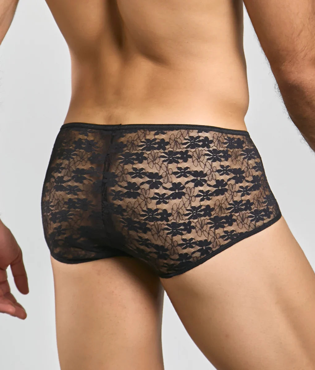 Black floral lace men’s briefs with a sheer patterned design shown from the back in the mob loop cheeky trunk style