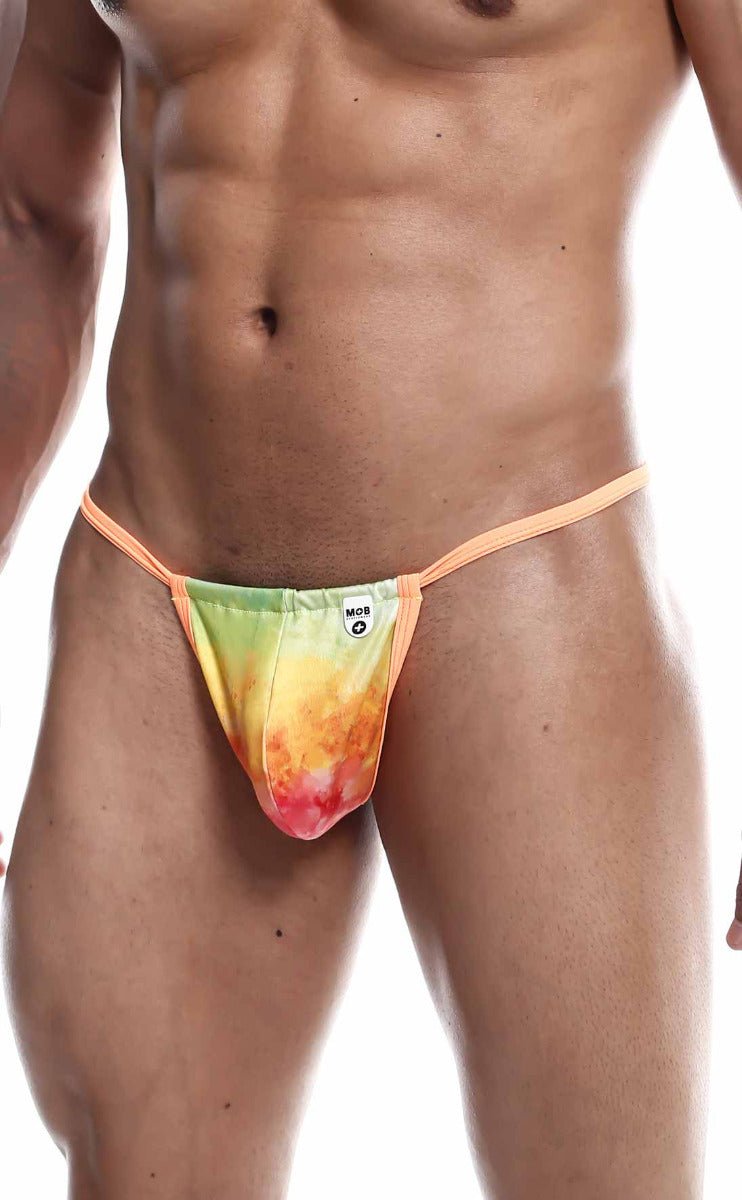 A vibrant tie-dye thong g-string in green yellow orange and red with peach elastic straps from mob print final sale