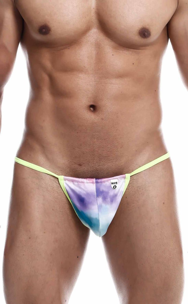 A vibrant tie-dye mob print g-string thong in purple blue and pink with a bright yellow elastic waistband