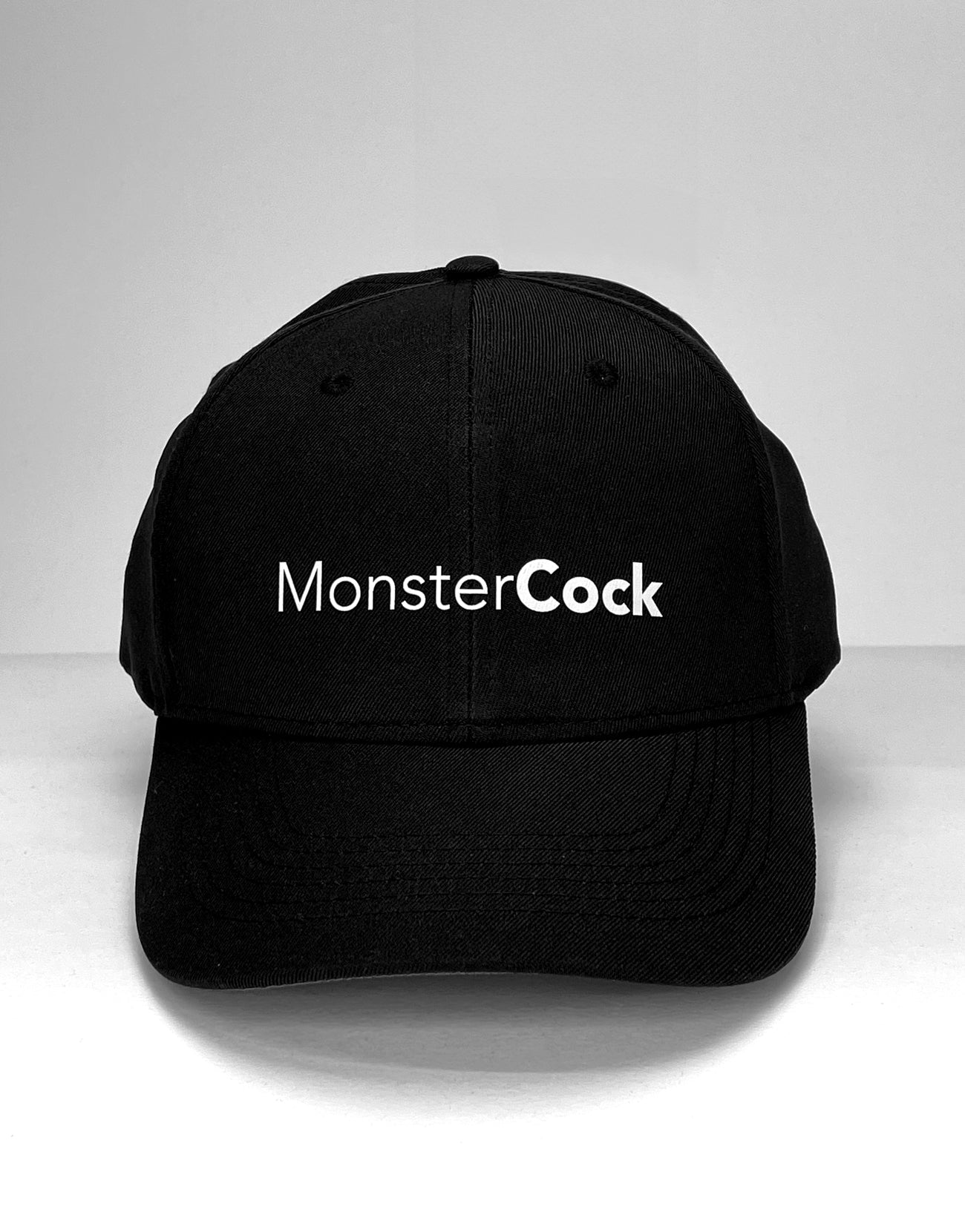Black baseball cap with "MonsterCock" printed in white, sans-serif font across the front.