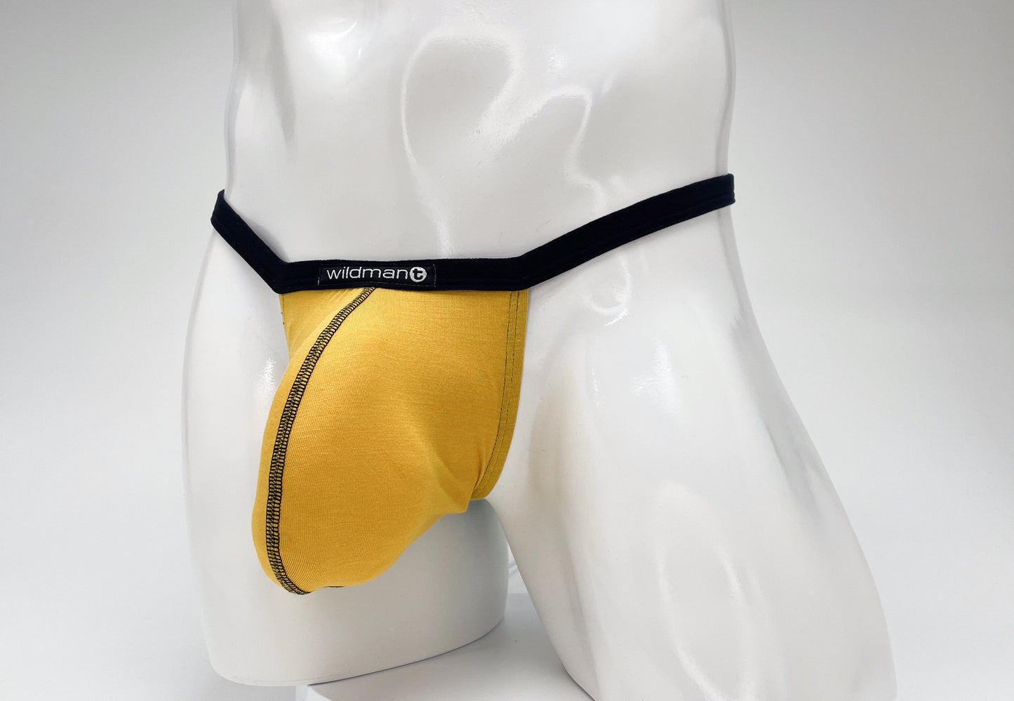 Gold modal micro thong with black waistband and trim on a white mannequin torso, featuring a prominent pouch.