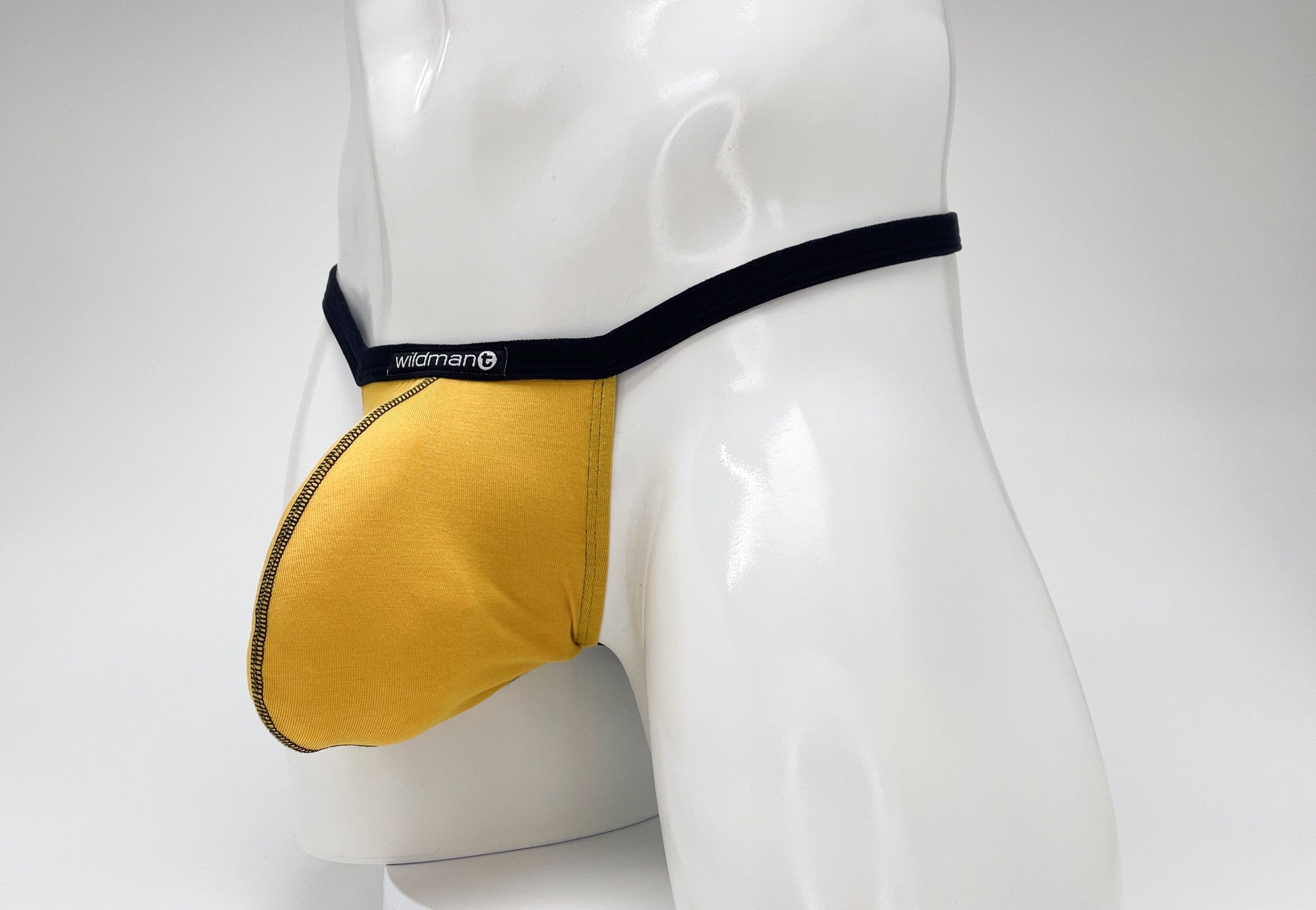 Gold Modal micro thong with black waistband and "WildmanT" logo on a white mannequin.