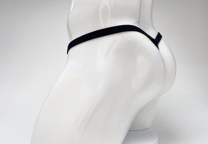 Black WildmanT modal micro thong on a white mannequin, showing the thin waistband and minimalist rear coverage.