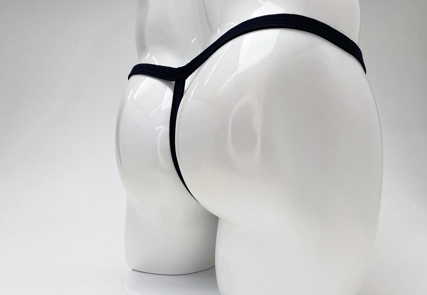 Black WildmanT modal micro thong on a white mannequin, showing a minimalist T-back design.