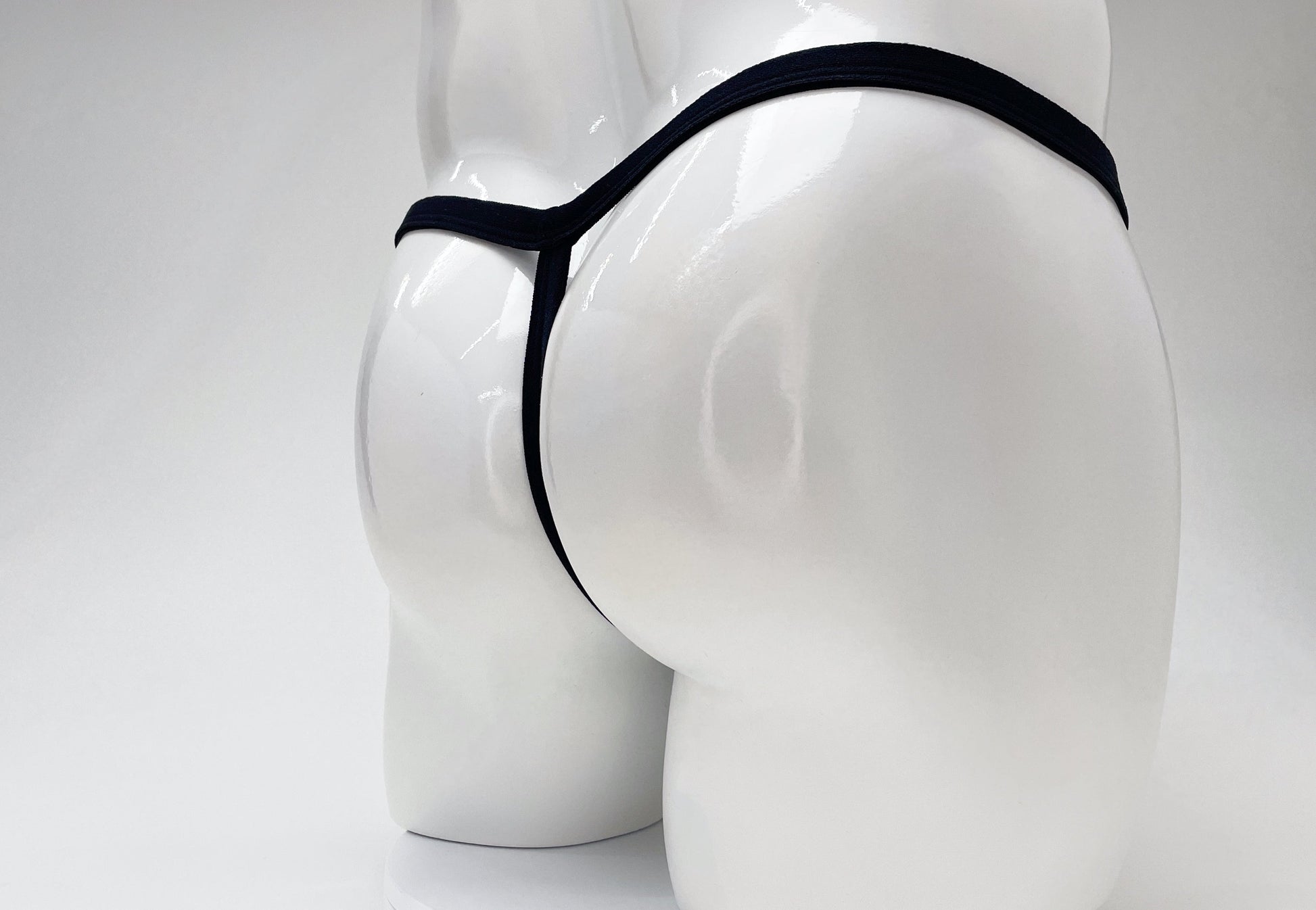Black WildmanT modal micro thong on a white mannequin, showing a minimalist T-back design.