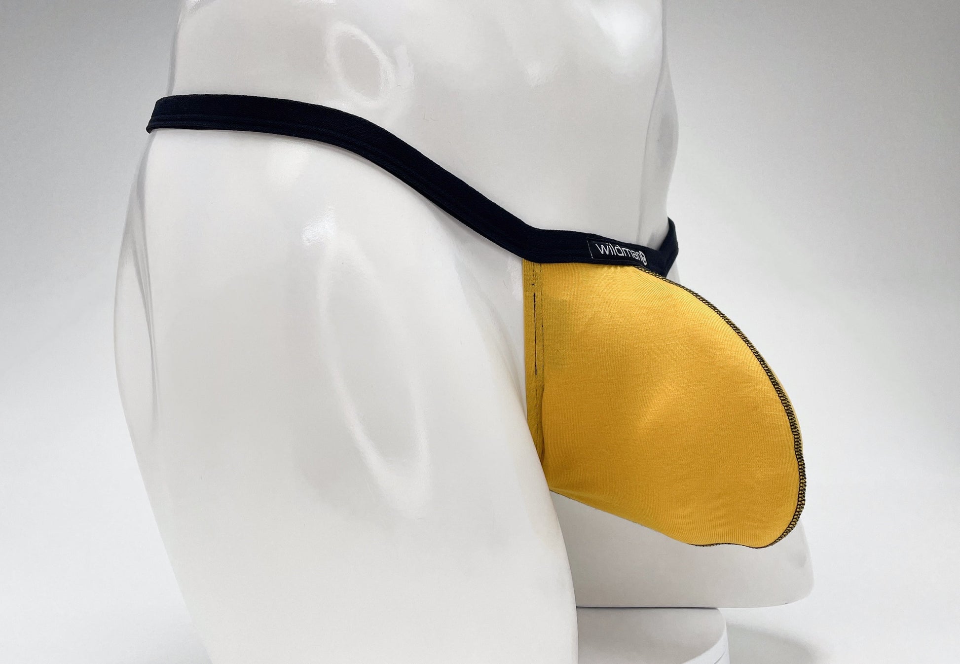 WildmanT gold modal micro thong with black waistband and "Big Boy" contoured pouch worn on a white mannequin torso.
