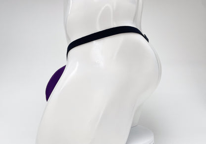 WildmanT purple modal micro thong with a big boy pouch on a white male mannequin, side view.