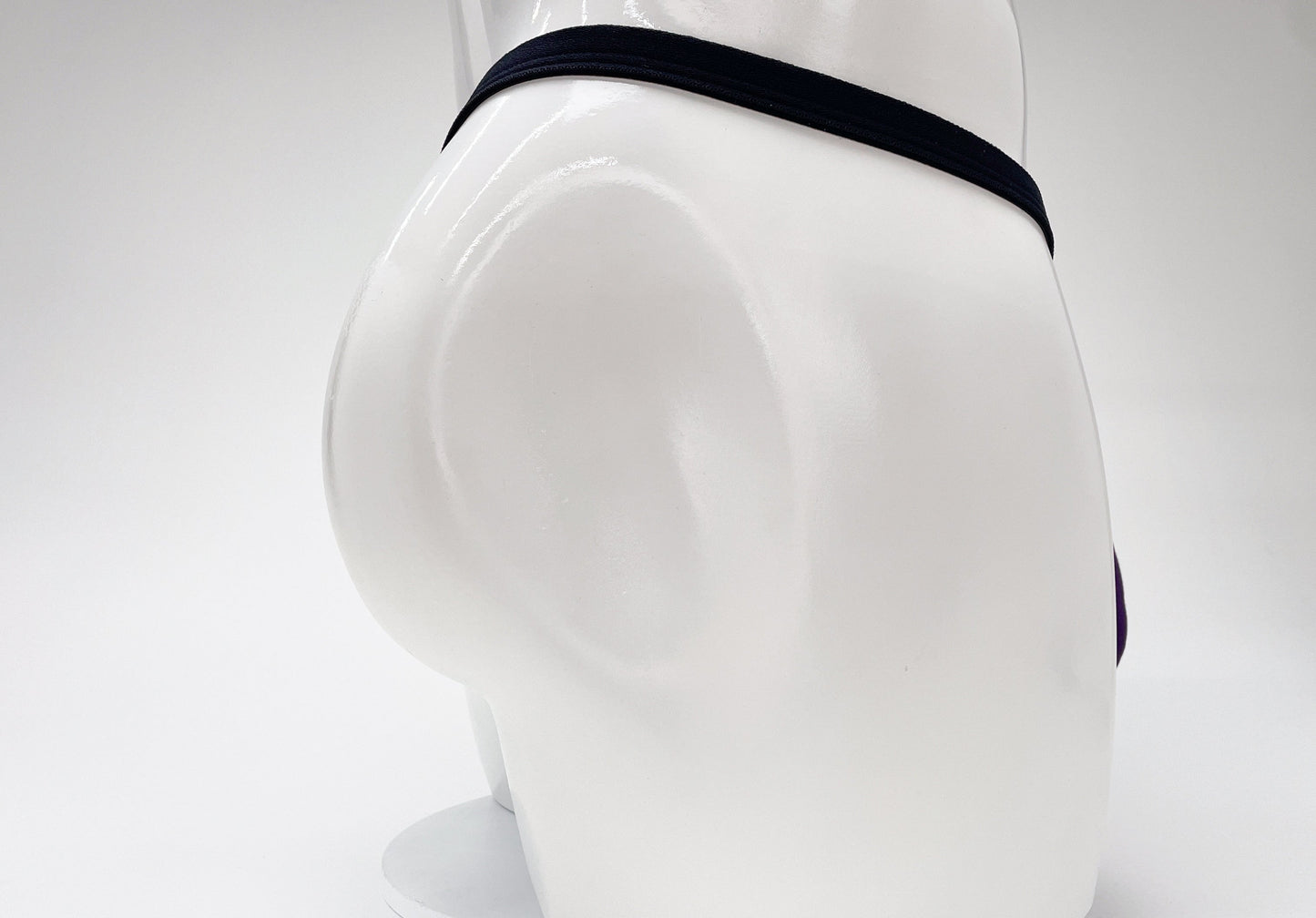 WildmanT purple modal micro thong with a thin black waistband on a white mannequin torso.