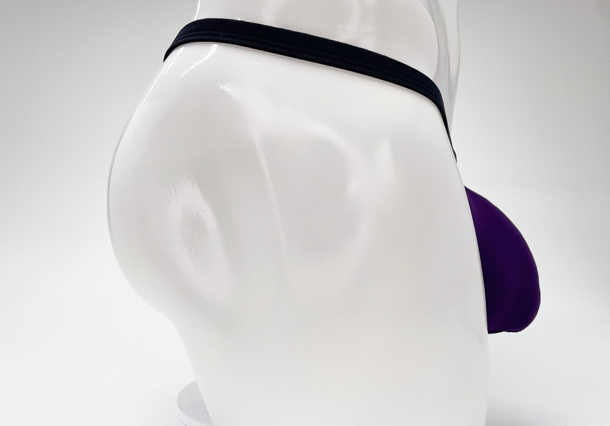 WildmanT purple modal micro thong with a prominent pouch, displayed on a white mannequin torso.