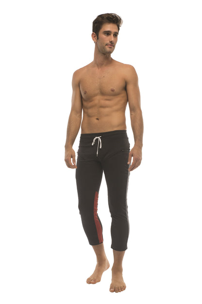 Mens black capri yoga pants with red side stripe white drawstring waistband and zipper pockets for athleisure use