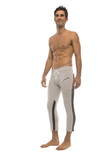 Mens 4/5 zipper pocket capri yoga pants in grey with black side stripes and white drawstring waistband for athletic use
