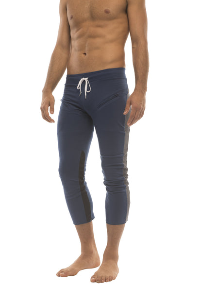 Mens navy blue capri yoga pants with white drawstring waistband and black side panels featuring zipper pockets