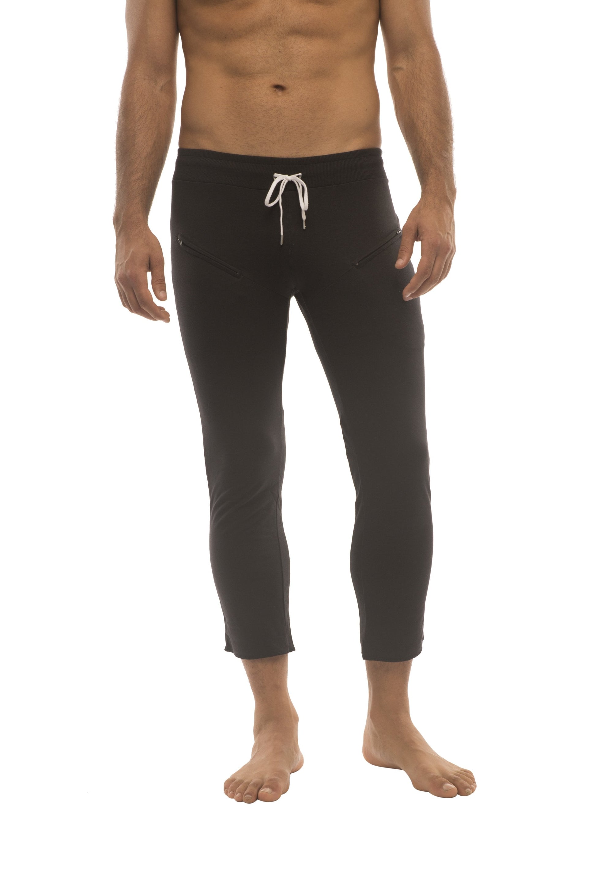 Mens solid black capri yoga pants with zipper pockets and white drawstring waistband for comfortable wear