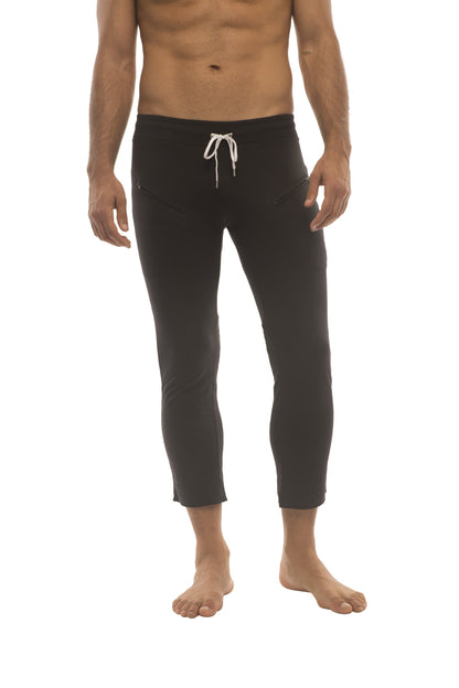Mens solid black capri yoga pants with zipper pockets and white drawstring waistband for comfortable wear