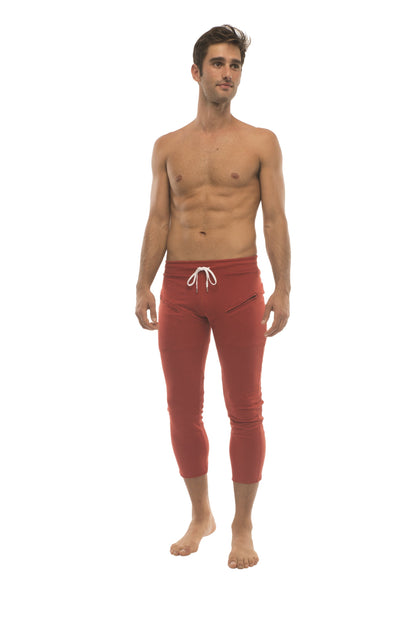 Mens 4/5 zipper pocket capri yoga pants in solid cinnabar red with white drawstring waistband and side pockets
