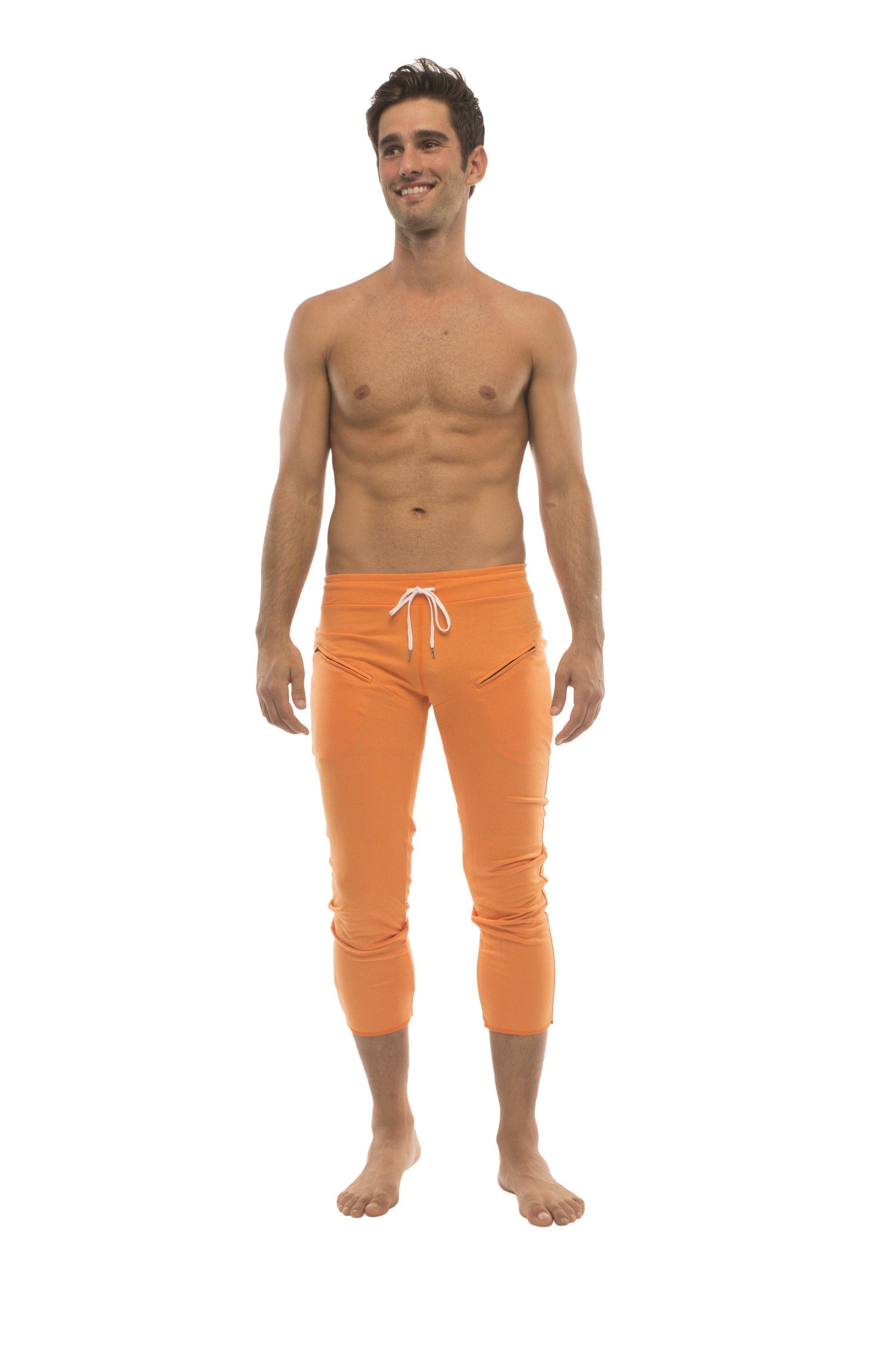 Mens solid orange capri yoga pants with white drawstring waistband and zipper pockets for athletic use