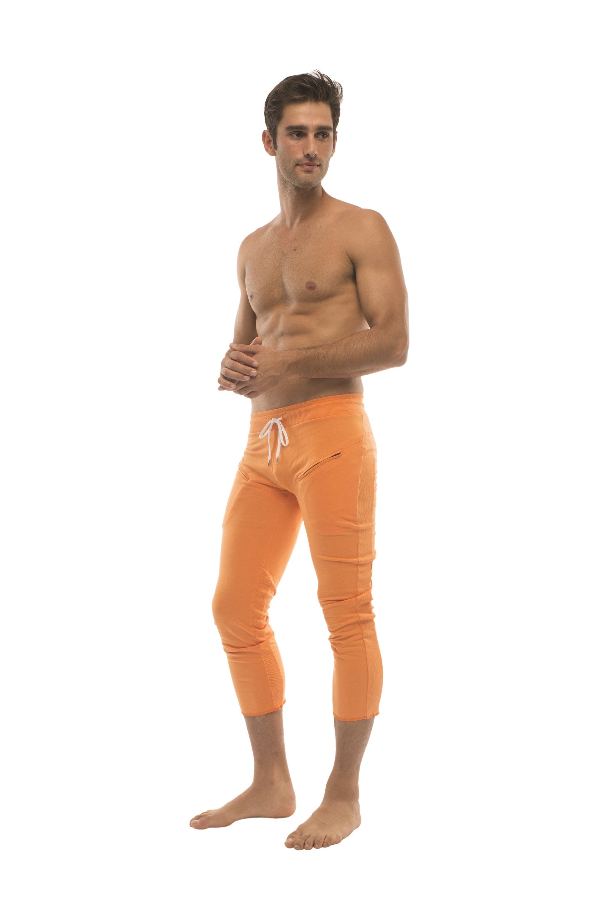 Mens solid orange athletic capri yoga pants with white drawstring waistband and 4 5 zipper pockets for active use