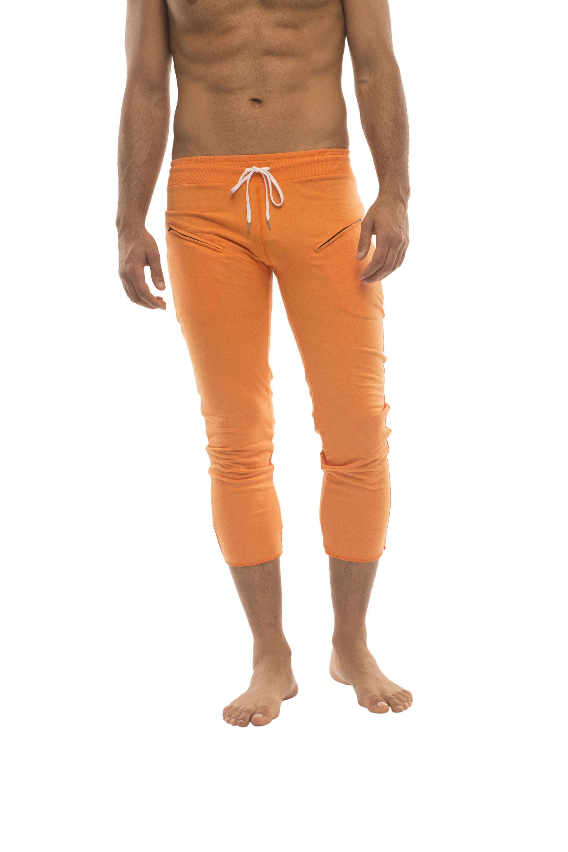 Mens solid orange 4/5 zipper pocket capri yoga pants with white drawstring waistband and subtle side pockets