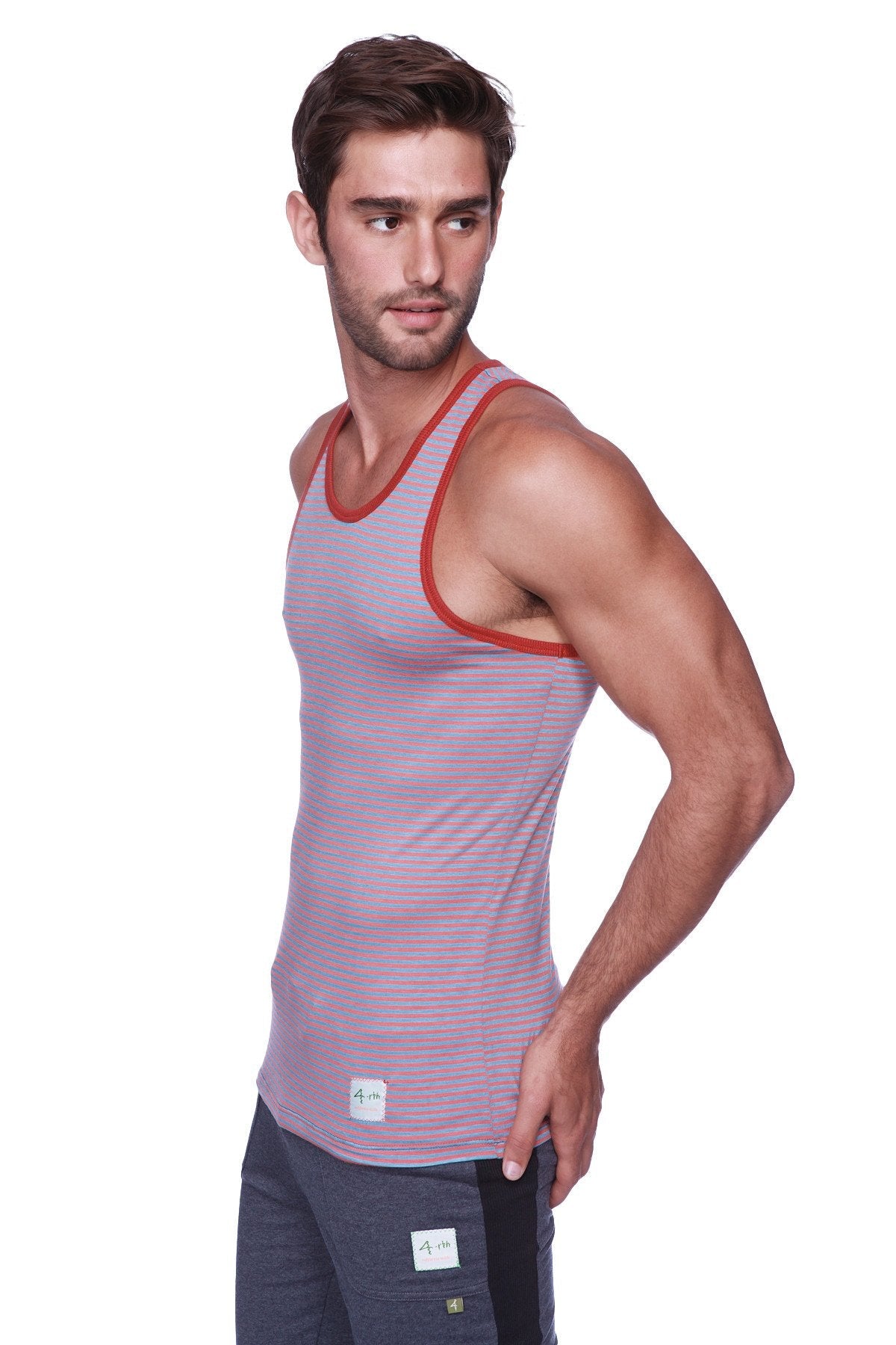 A men’s light purple tank top with thin red stripes and red trim paired with charcoal cuffed yoga pants