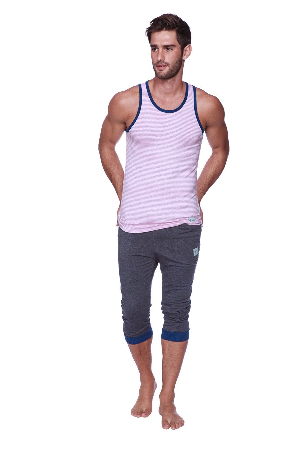 A man wearing mens cuffed charcoal yoga pants with royal blue trim and a pink and white striped tank top