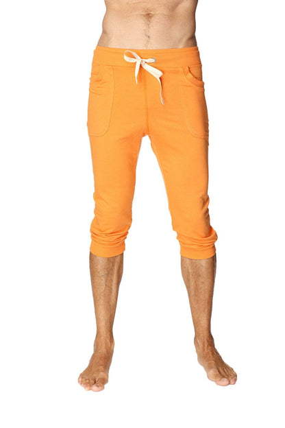 Mens cuffed yoga pants in solid sun orange with bright orange cropped jogger style and white drawstring waistband