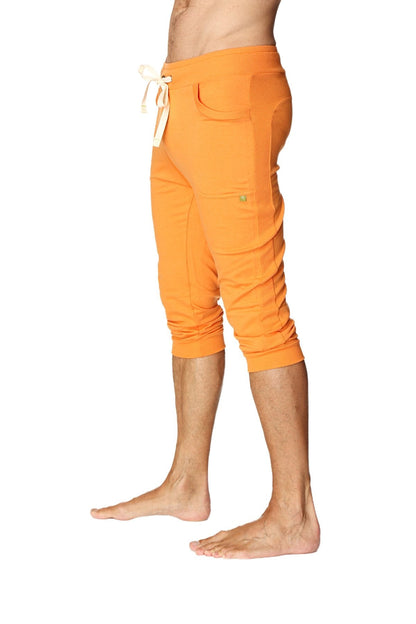 Mens cuffed yoga pants in solid sun orange with white drawstring waistband multiple pockets and capri length