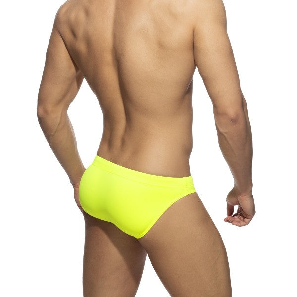 Bright neon yellow swim trunks made of lightweight fabric designed for vibrant beachwear use