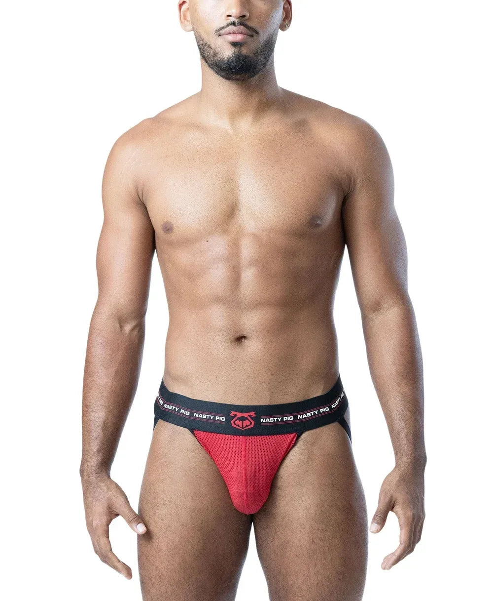 Model wearing a black and red mesh jockstrap by Nasty Pig featuring a logo waistband and a snug fit.