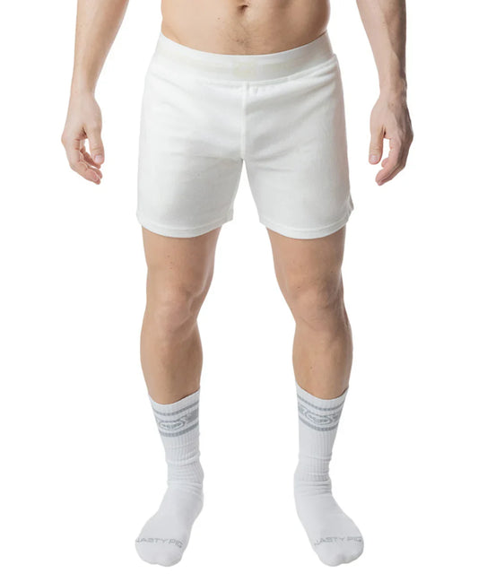 Cream-colored rugby shorts underwear on a person standing, paired with white mid-calf socks.