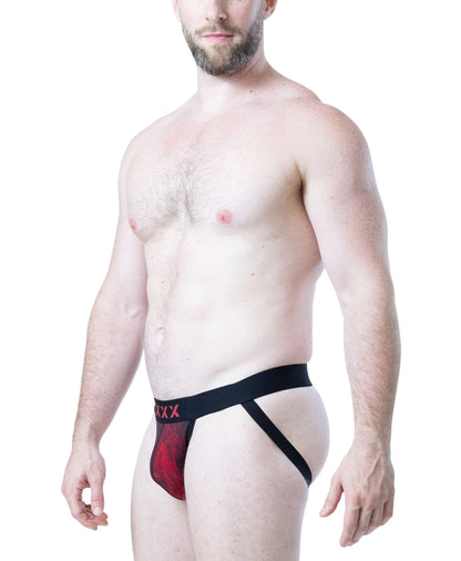 Model wearing a black jockstrap with red flame design and logo from Nasty Pig showcasing a comfortable fit and minimal coverage