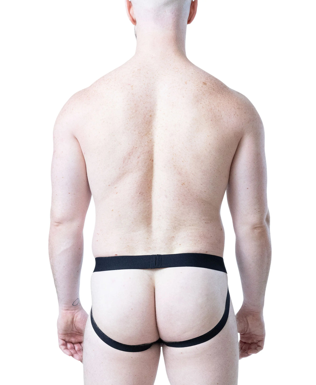 Black jockstrap with minimal coverage featuring a comfortable waistband worn by a model from behind by Nasty Pig