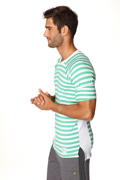 A man wearing a green and white stripe nautical raglan resort henley tee with short sleeves and crew neck