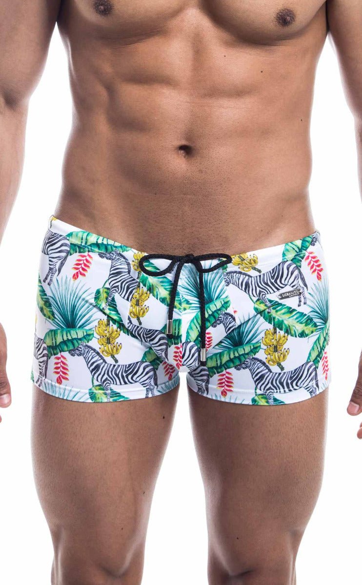 White oceanico square cut swim trunks with vibrant tropical zebra print green palm leaves red flowers and black drawstring waistband
